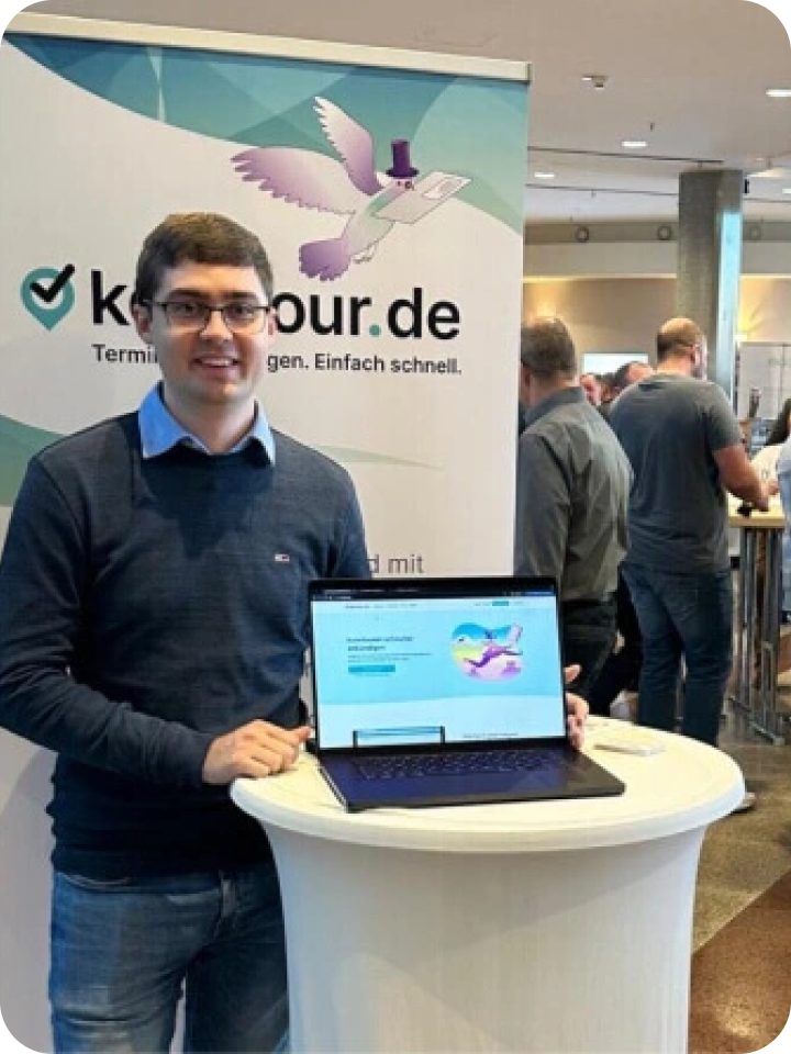 Kevin Kirch mit Laptop vor einem Kehrtour.de-Banner